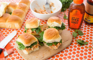 Chicken slider sandwiches, Nate's honey bottle, and rolls on a polka dot tablecloth. Chicken slider sandwiches, Nate's honey bottle, and rolls on a polka dot tablecloth.