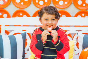 A happy child in costume enjoys a Nate's honey mini, surrounded by a lively, themed decor.