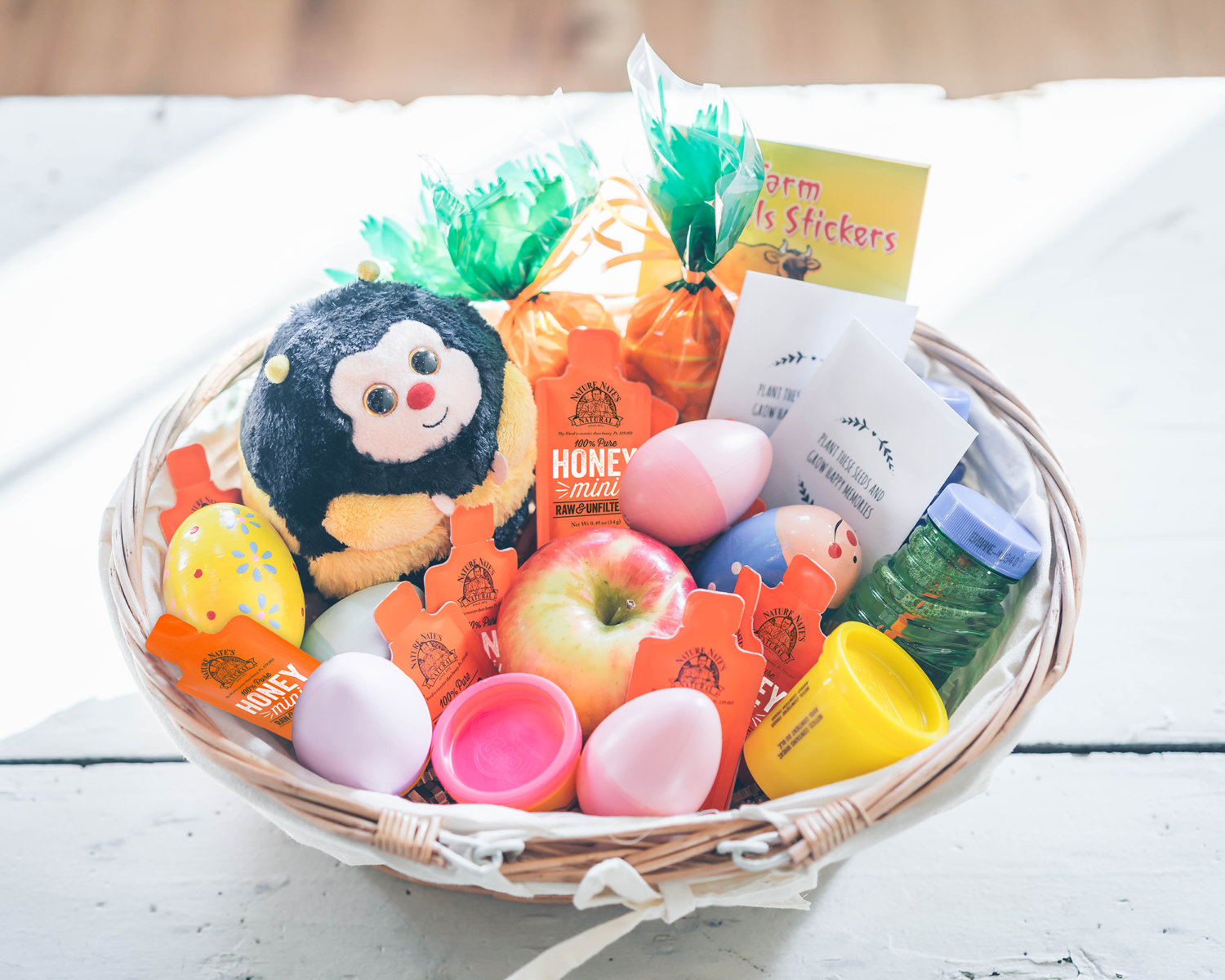 A cheerful Easter basket filled with treats, toys, eggs, and Nate's honey minis. Festive and sweet!