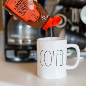 Nate's honey being poured into a coffee mug.