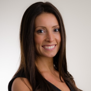 A smiling woman with long dark hair wearing a black sleeveless top.