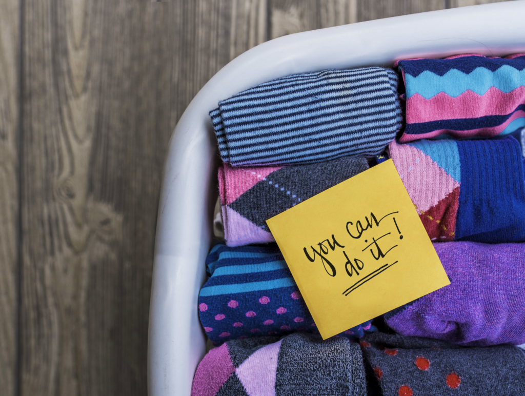 Folded colorful socks in a laundry basket with an encouraging note. Folded colorful socks in a laundry basket with an encouraging note.