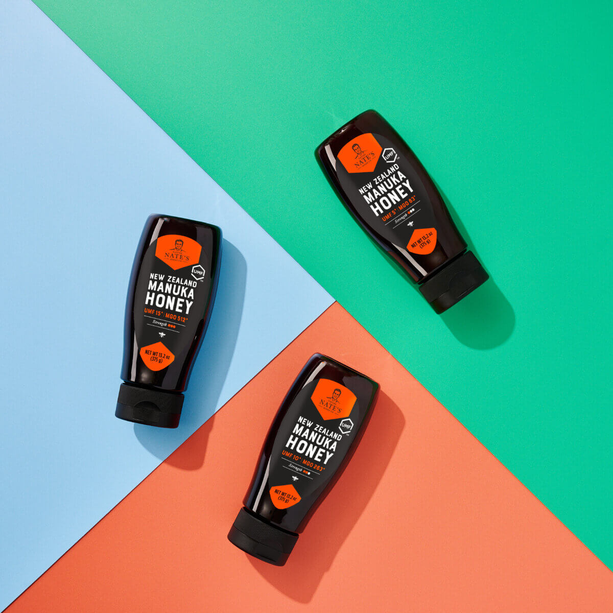 Three bottles of Nate’s New Zealand Manuka Honey UMF™ 5+ on a colorful background.
