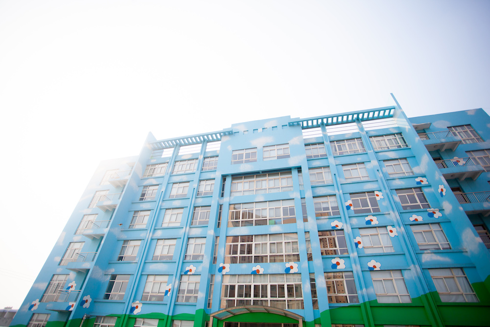 Blue building facade under a clear sky.