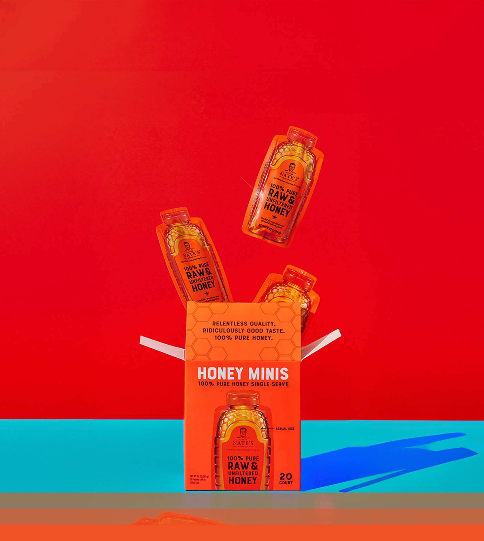 Orange honey minis box with top flap open and three honey mini packets popping out the box top.