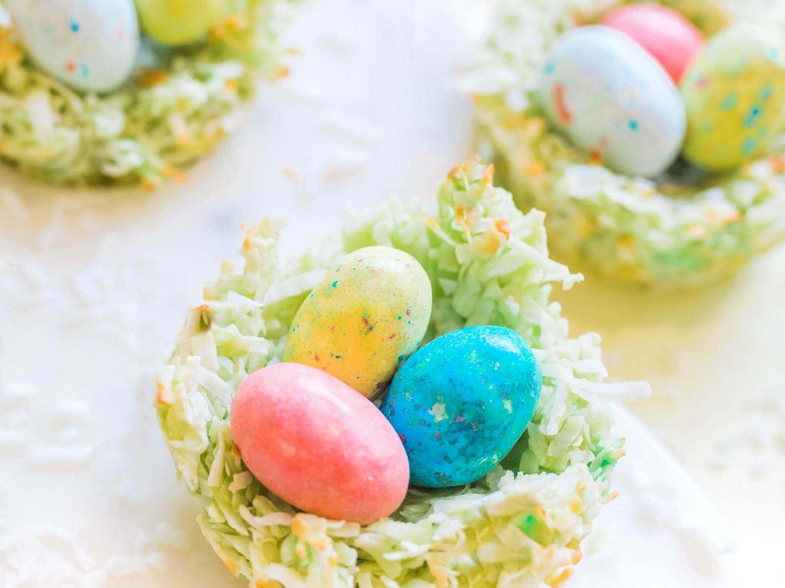 Colorful candy Easter eggs nestled in sweet, coconut nests, ready for the springtime holiday.