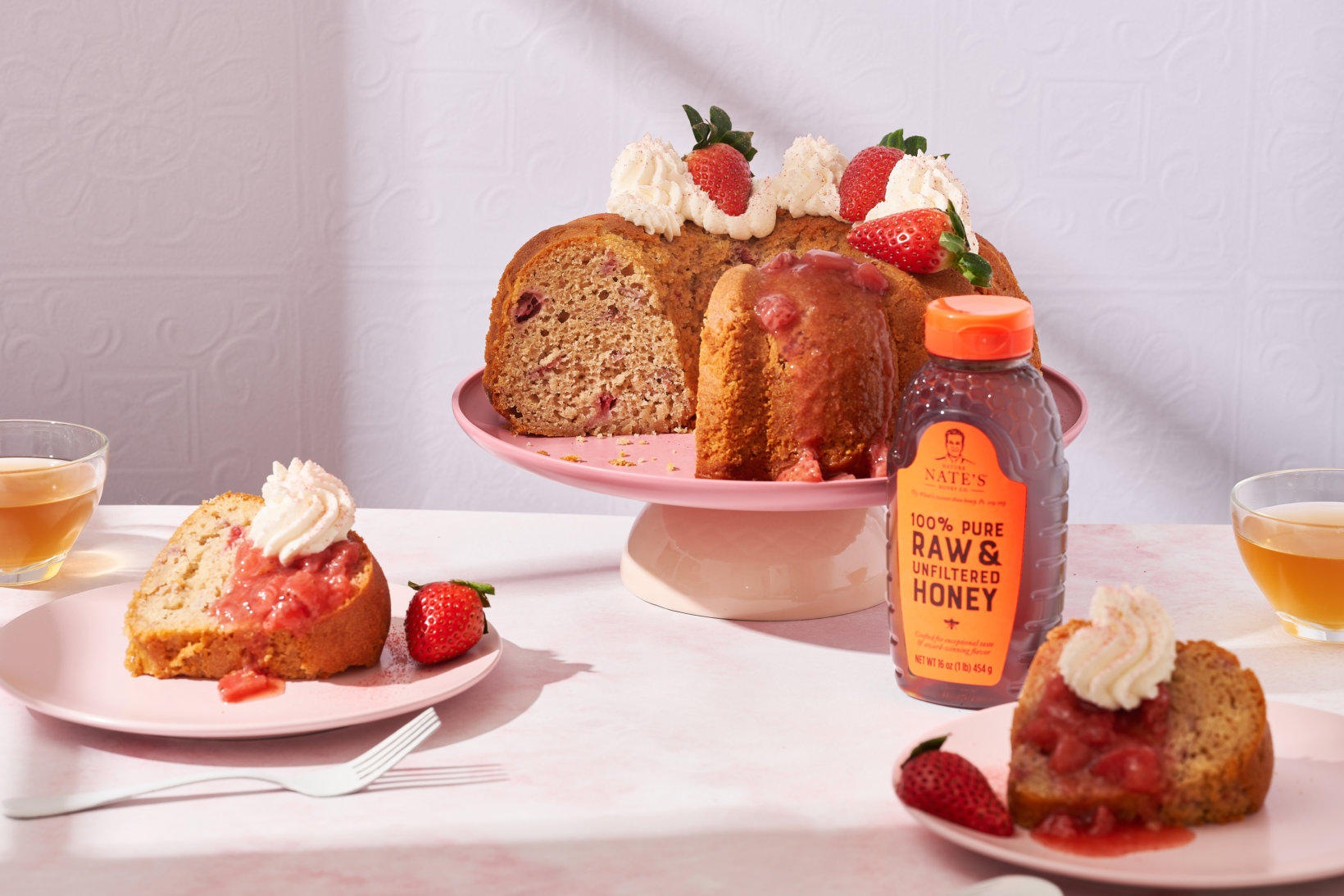  Strawberry cake sliced and served with whipped topping and a bottle of Nate’s honey and tea.