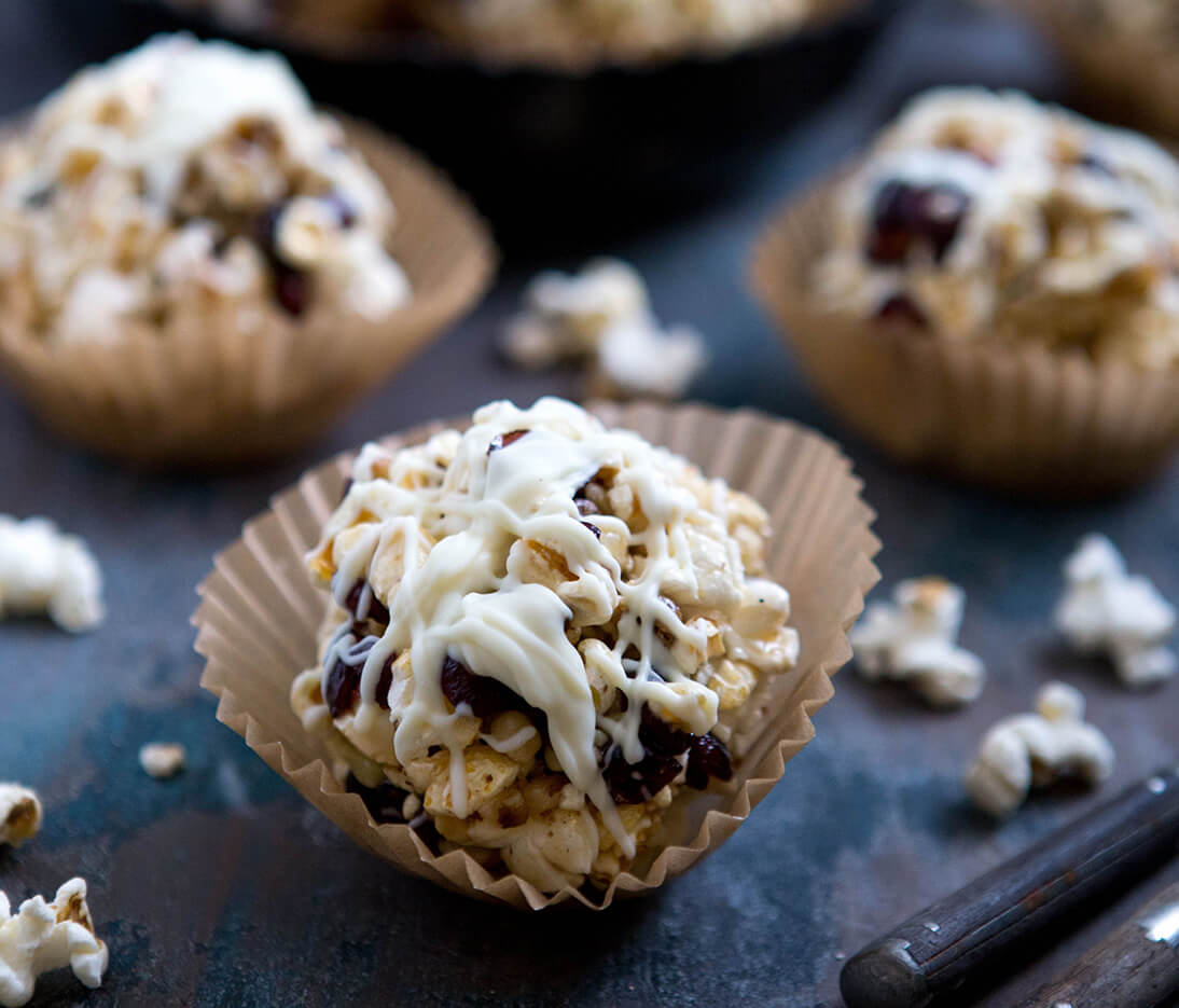 Popcorn balls made with Nate's honey, with dried cranberries, walnuts and a white chocolate drizzle, a sweet treat.