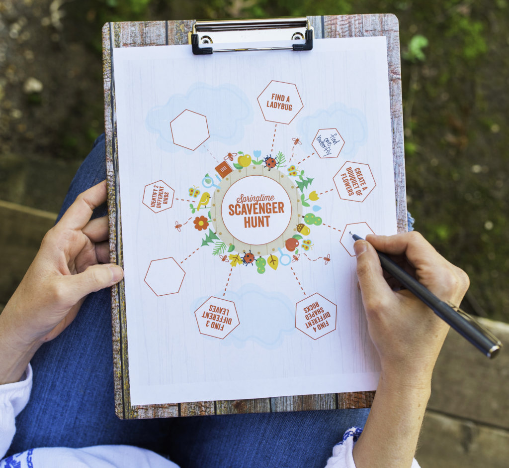 Hands holding clipboard with colorful scavenger hunt map, fun outdoor activity concept. Hands holding clipboard with colorful scavenger hunt map, fun outdoor activity concept.