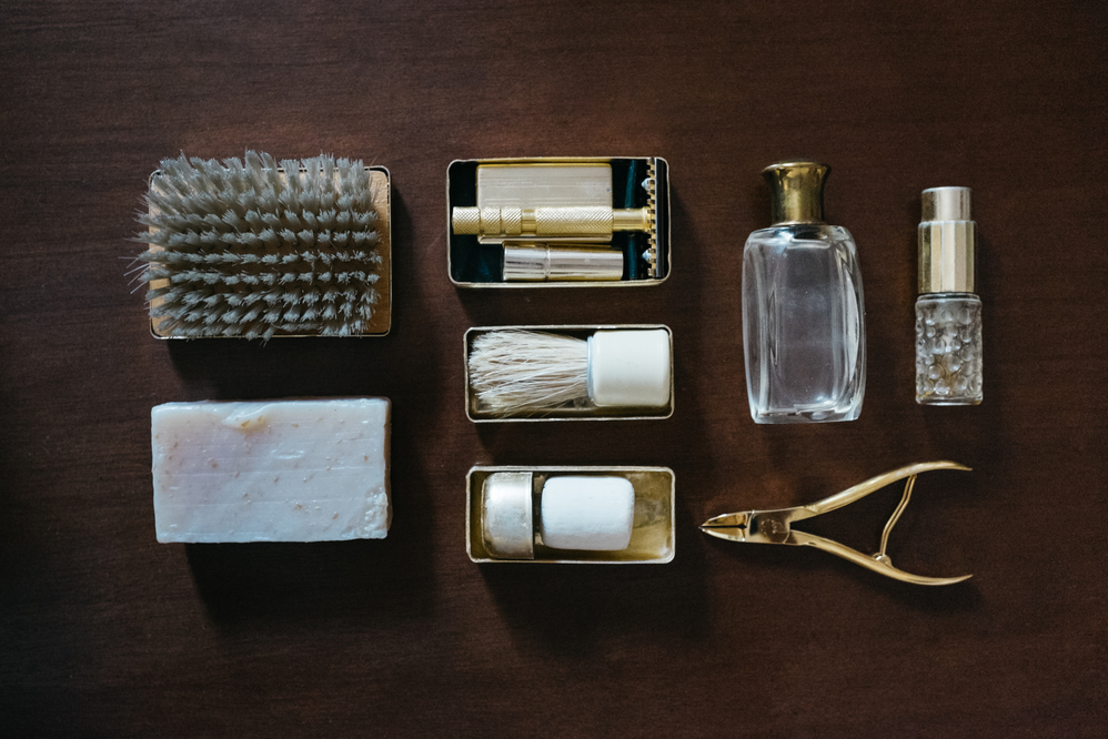 Men's grooming items neatly arranged on a dark wooden surface.