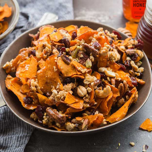 Sweet potato chips with nuts, granola and dried cherries, Nate's honey bottle in background.