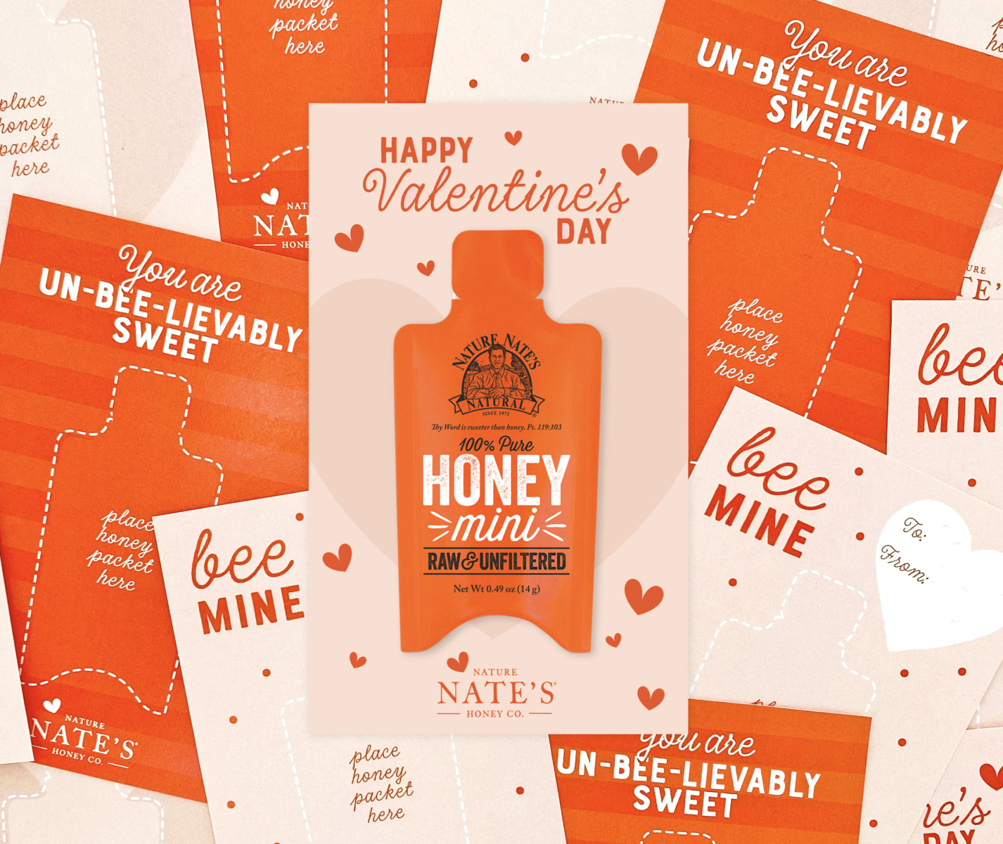 Valentine's themed cards with puns like Bee Mine and Un-Bee-lievably Sweet scattered around a central Nate’s honey mini.