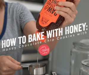 Pouring Nate's honey into a cup with text HOW TO BAKE WITH HONEY: Honey Chocolate Chip Cookies.